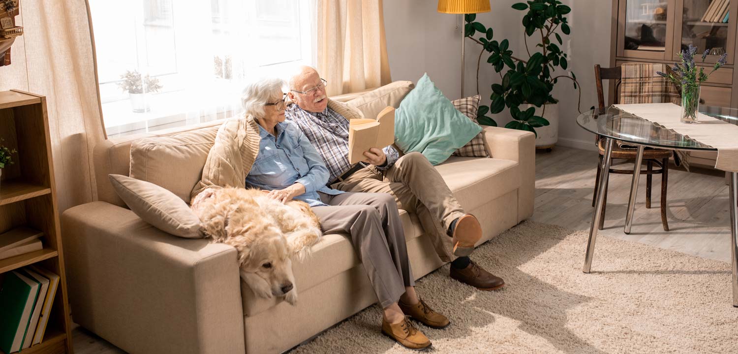 aelteres-paar-mit-hund-auf-couch